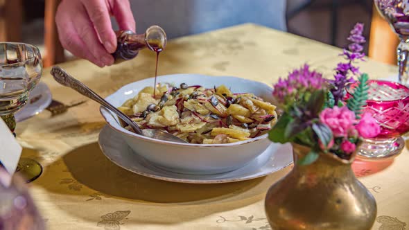 A slow-mo shot of a hand pouring syrup on a dessert.