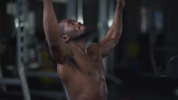 Medium Shot of Muscular Confident African American Sportsman Using Pulldown Machine in Gym Indoors