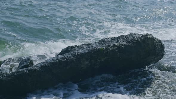 Waves Break on Rocks in Blue Ocean
