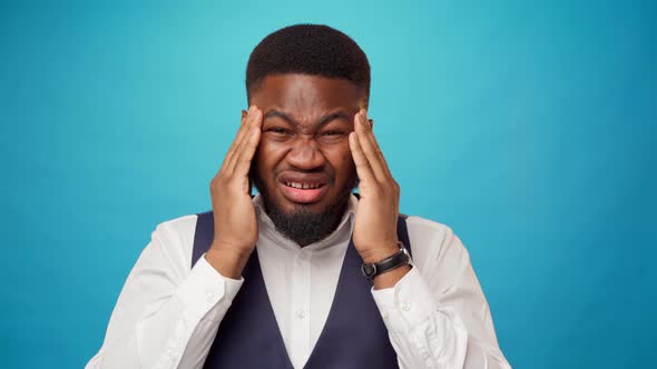 Young African Man Suffering From Headache Massaging His Forehead Blue Background