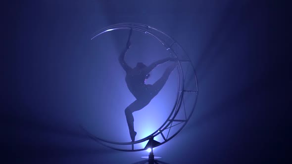 Gymnast in a Costume Performs Tricks in a Dark Room