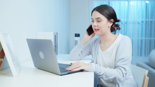 Asian young beautiful businesswoman use mobile phone call working at home during night time