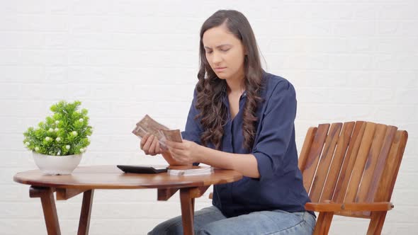 Confused Indian girl counting money