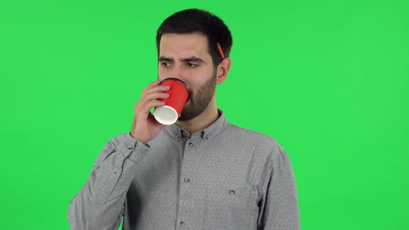 Portrait of Brunette Guy Drinking Unpalatable Coffee and Is Disgusted. Green Screen