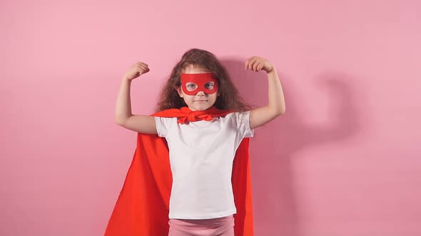 Portrait of Strong Little Girl in Superhero Cloak and Mask