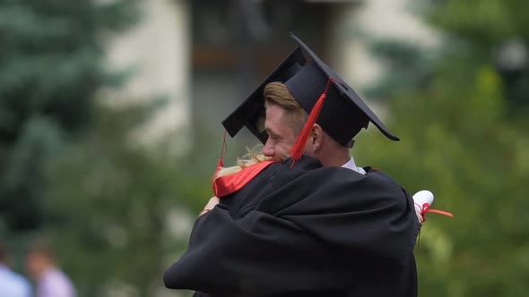 Male and Female Friends Hugging, Holding Higher Education Diplomas in Hands