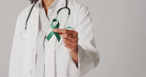 Video of biracial female doctor holding emerald liver cancer ribbon