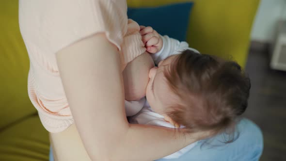 Close Up of Little Newborn Baby While Sucking Mothers Breast Milk