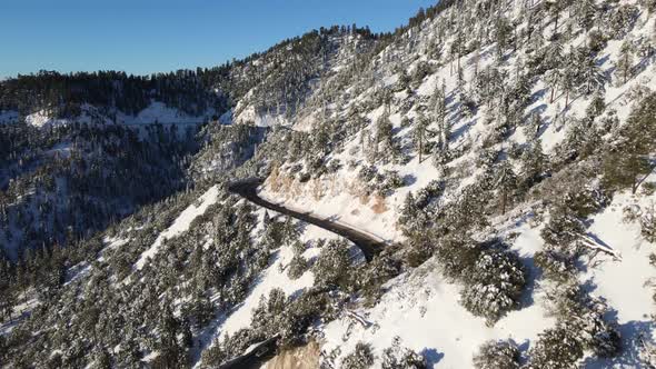 Aerial of a road through the mountains after a snow