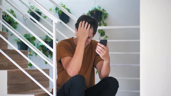 Sad Man Reacting to Loss on Message on Smartphone
