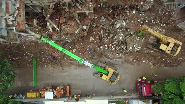 Aerial view above of workers dismantling a abandoned building, Cambodia.