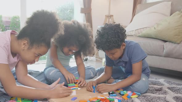 Happiness family with children playing block wood on floor together with fun and relax.