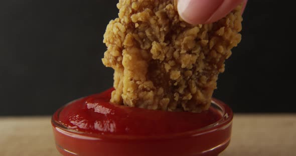 Chicken Wing Is Dipped Into A Ketchup Bowl On A Table With Black Background A Macro Shot