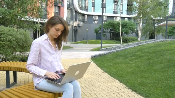 Young Woman Typing on Keyboard of Laptop Businesswoman Using Digital Tablet Outside on Modern