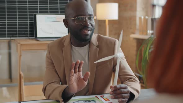 Afro-American Engineer Discussing Windmill Turbine with Colleague