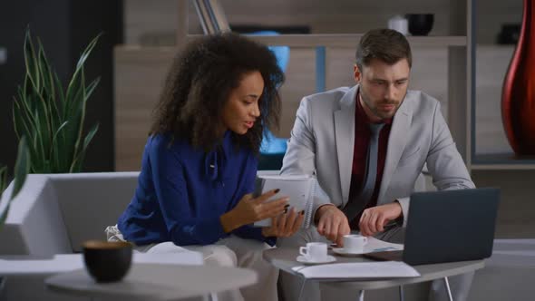 Multiracial Coworkers Team Discuss Marketing Project Using Laptop in Cafe Office