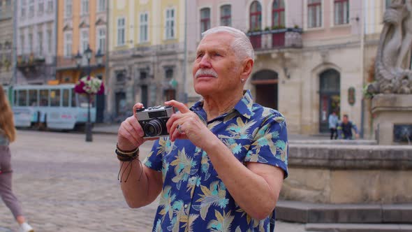 Senior Man Tourist Taking Pictures with Photo Camera in Summer City Center Life After Retirement