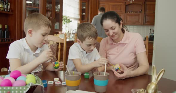 Mom Helps Her Sons Paint Easter Eggs