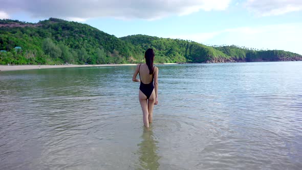 Pretty Asian Woman in Black Swimsuit Walking Alone in the Sea Thailand