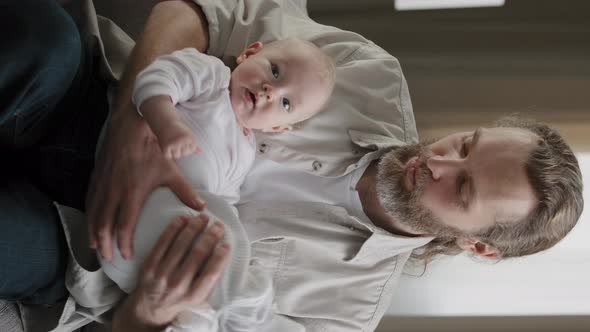 Bearded 30s Happy Single Dad Parent Father Sings Lullaby to Newborn Cute Son Daughter Child Infant