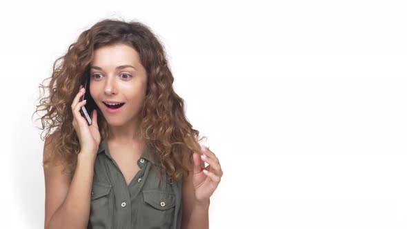 Lovely Woman with Long Curly Hair Having Pleasant Mobile Conversation Over Smartphone Smiling