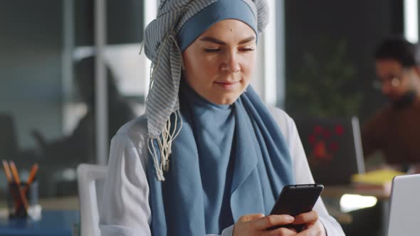 Businesswoman in Hijab Using Smartphone and Posing for Camera