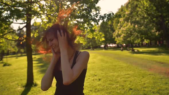 Beautiful Redhead Girl with Long Hair Enjoys Music