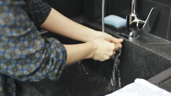 Woman wipes hands with dry towel after washing hands