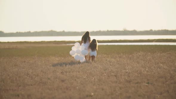 Mother with Daughter and White Balloons