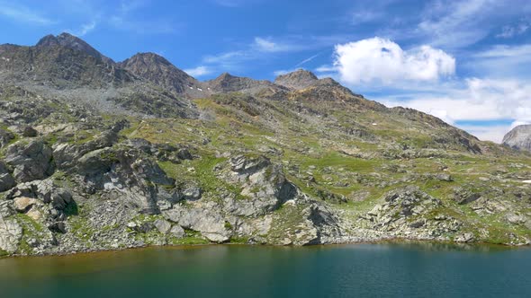 PAN: Idyllic blue alpine lake high up on the mountains, scenic landscape rocky terrain at high altit