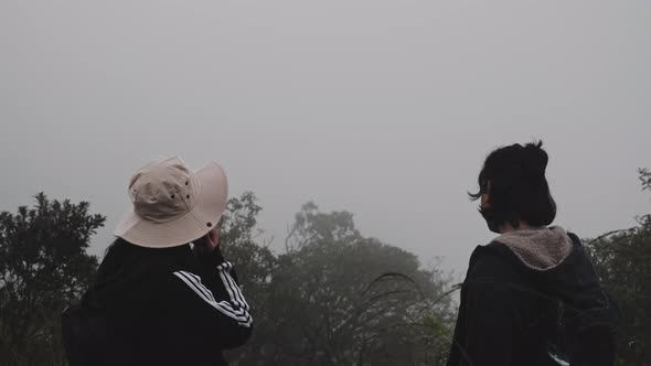 Couples of Asian tourists enjoy taking photos on top of the mountain.