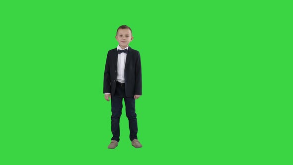 Boy in a Suit Greeting You Walks in and Out on a Green Screen, Chroma Key.