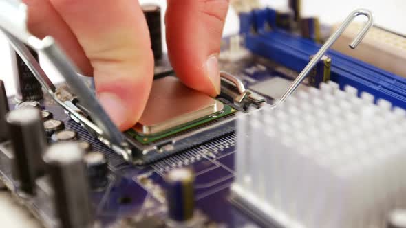 Technician fixing chip on motherboard