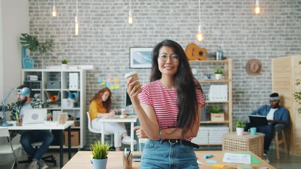 Portrait of Beautiful Asian Businesswoman Standing in Office with To Go Coffee