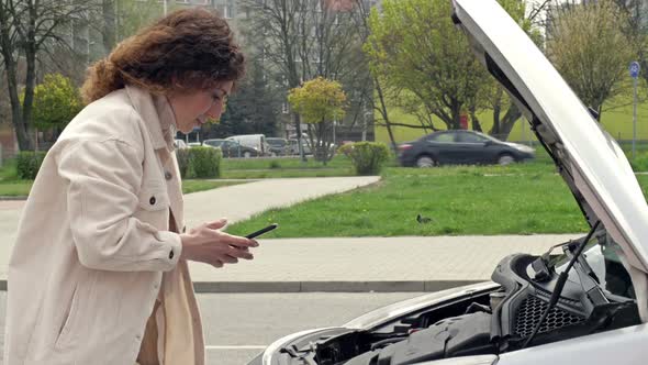 Woman Talking By Phone Looking at Broken Car Motor Calls to Evacuation Service Open Hood Call to