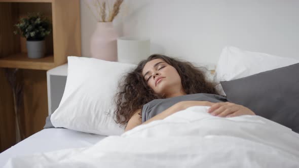 Pretty Young Woman Sleeping in Cozy Bedroom in the Morning