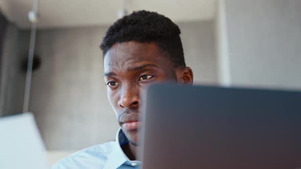 Young african american male professional working at computer in home office