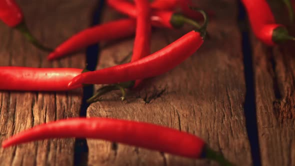 Super Slow Motion Red Chilli Rolls on Wooden Boards