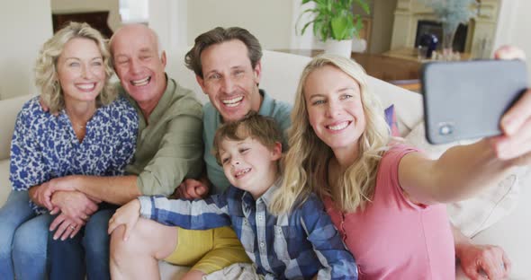 Happy caucasian family taking selfie and sitting in living room