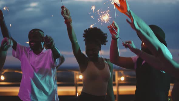 People with Sparklers Jumping and Dancing at Rooftop Party