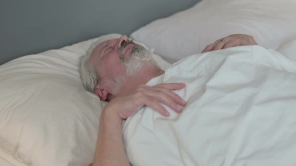 Restless Old Man Trying Sleeping in Bed 