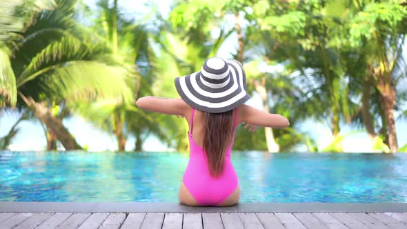 Young asian woman enjoy around outdoor swimming pool for leisure