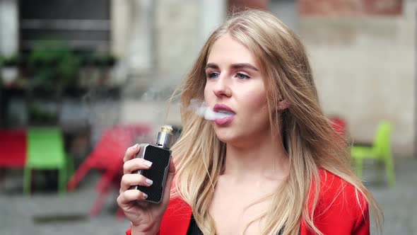 Stylish Young Girl in a City with Vape