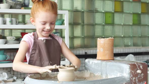 Kid Is Working at Pottery Wheel Slowly and Molding a Vase