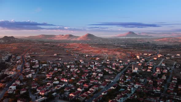 Aerial Drone Footage of Cappadocia Town and Mountains on the Background