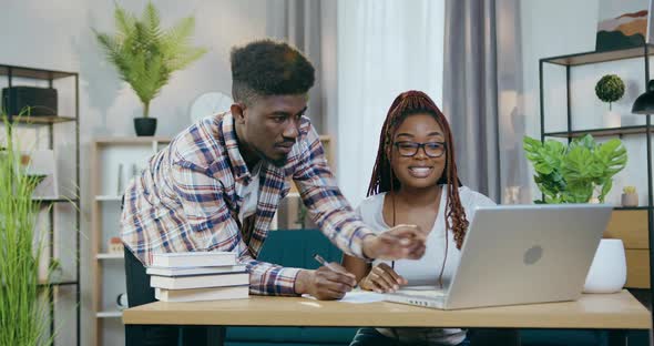 African Couple Surfing Internet on Laptop at Home
