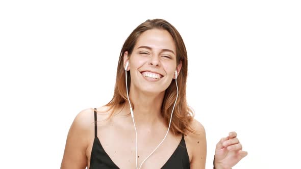 Young Beautiful Girl Dancing Singing Listening Music in Headphones Over White Background