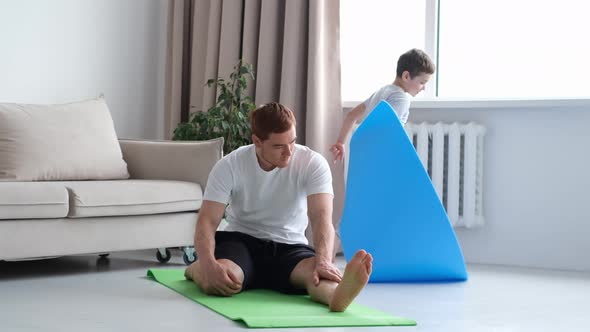 Dad Doing Morning Exercises While Active Energetic Child Son Playing