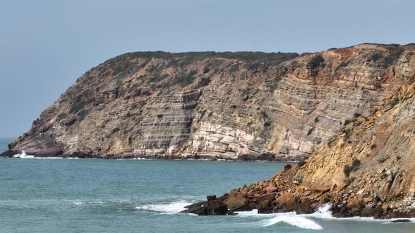 Aerial panning shot of rugged cliffs along the coast of the Atlantic Ocean