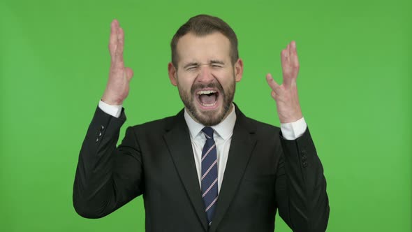 Frustrated Young Businessman Screaming in Anger Against Chroma Key